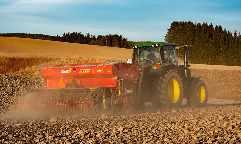 John Deere traktor sår på jordet med rapid såmaskin