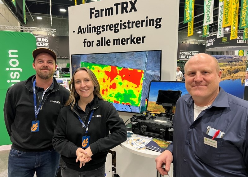 Tre personer foran en skjerm og en koffert med utstyr.