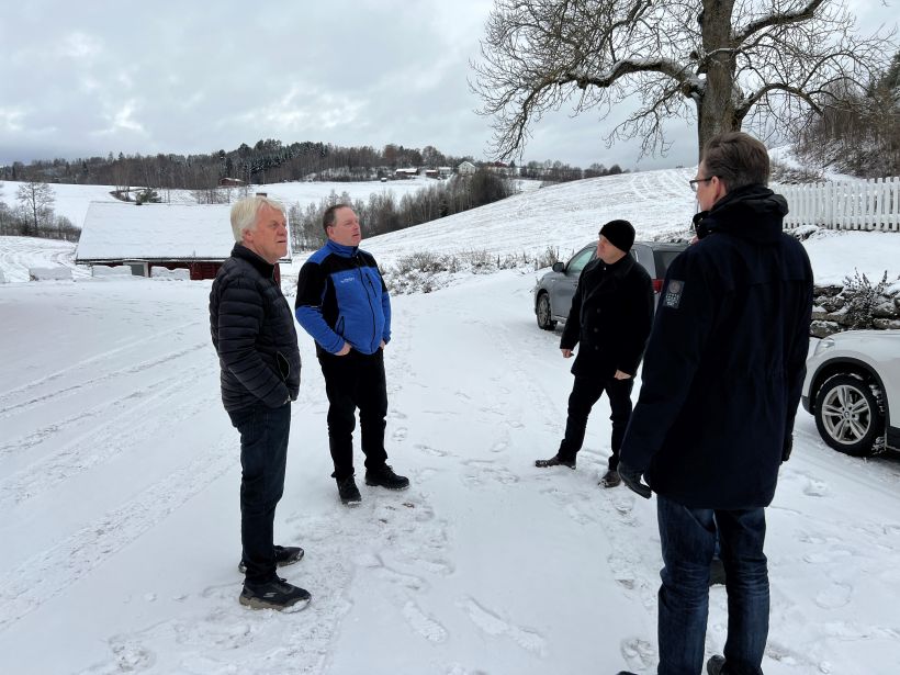 4 karer ute på tunet med bratt bakke i bakgrunnen