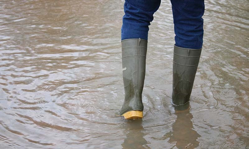 To ben i gummistøvler - stående i flomvann