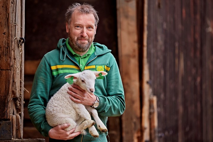 Bonde som holder et lam