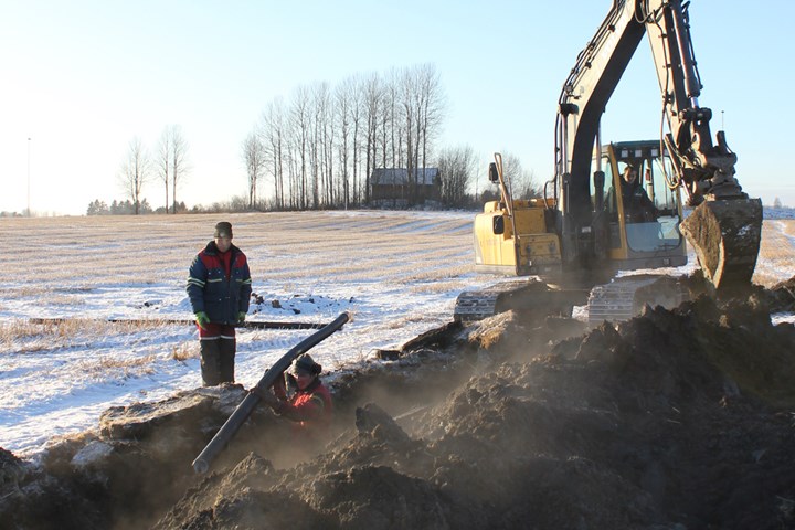 Gravemaskin og mann, grøftearbeid i Løten.
