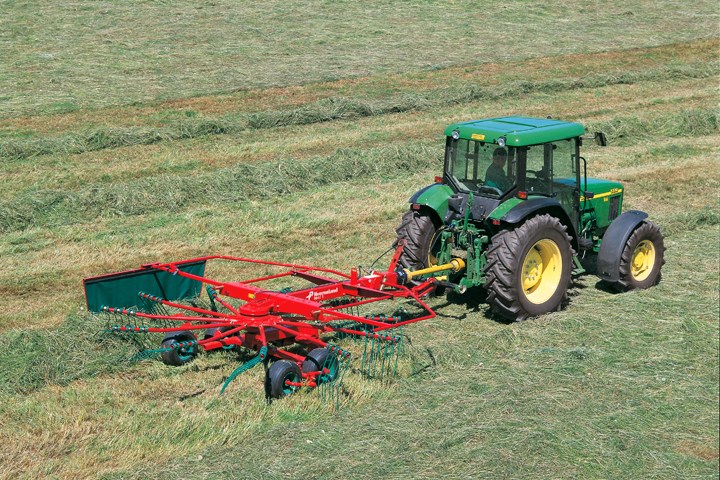 Traktor i arbeid med gress