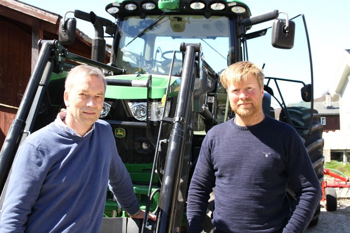 Maskinselger og kunde med John Deere traktor. Foto
