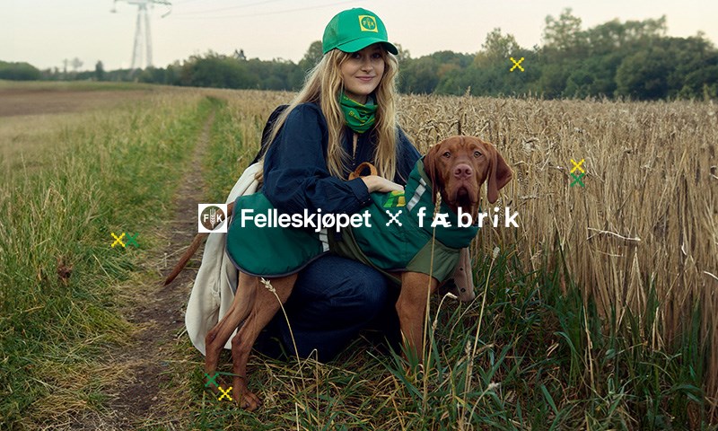 Avbildet: Dame og hund i åker, hund i hundedekken laget på felleskjøpet klær